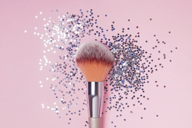 彩妆刷和星形五彩纸屑粉背景，俯视图。图片下载