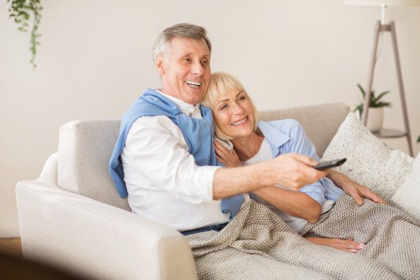 放松的老夫妇在家里看电视图片下载