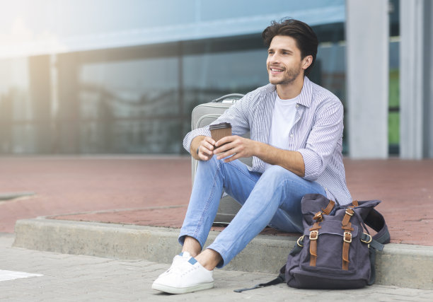 无忧无虑的千禧一代享受着咖啡，在机场附近等待航班图片下载