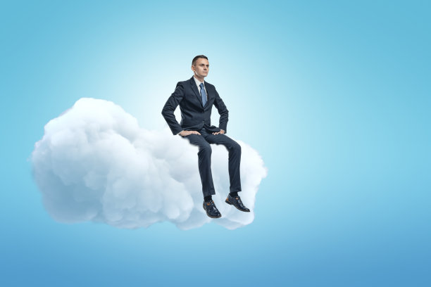 一个年轻的商人坐在蓝天上一片蓬松的白云上，还有很多的复印空间。图片下载