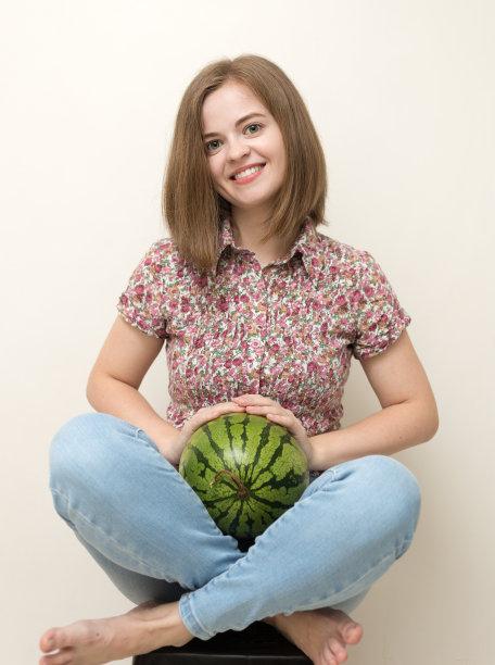 微笑的白人女子的肖像与绿色西瓜在她的手。健康的生活方式，水果素食饮食。图片下载