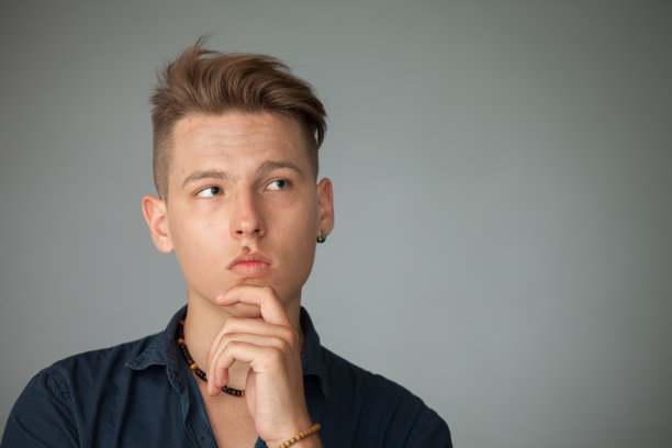 一个在灰色背景上的16岁少年的工作室肖像图片下载