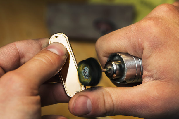 一个珠宝商在车间打磨一个金坯，特写图片下载