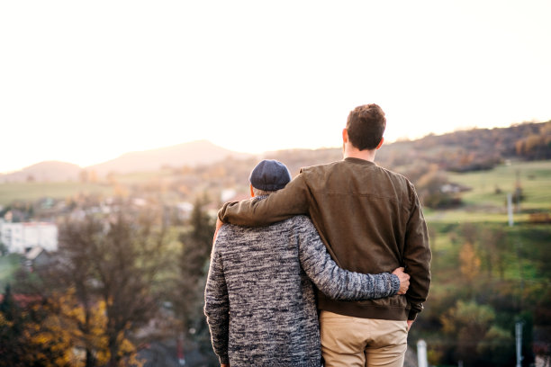 老父亲和他的儿子在公园里散步，站着。图片下载