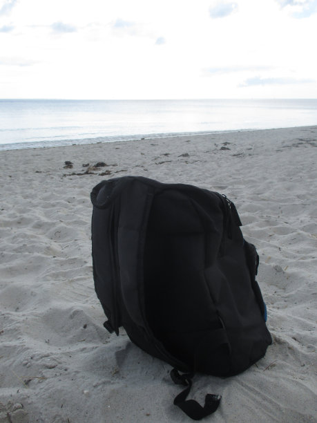 背包躺在沙滩上图片下载