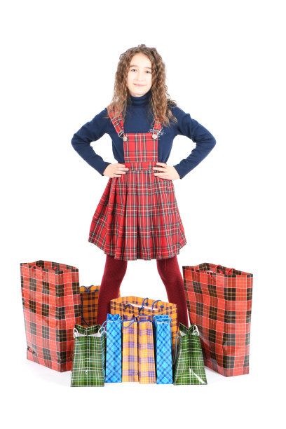 儿童与包装方格纹理隔离在白色背景。女孩喜欢在打折季购物。节日礼物,购物。图片下载