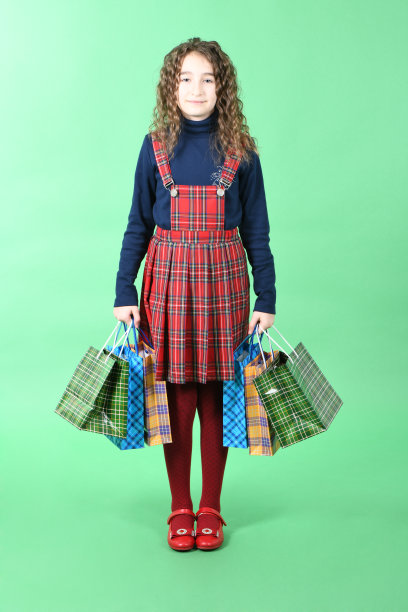 儿童与包装方格纹理隔离在白色背景。女孩喜欢在打折季购物。节日礼物,购物。图片下载