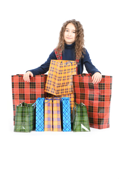 儿童与包装方格纹理隔离在白色背景。女孩喜欢在打折季购物。节日礼物,购物。图片下载