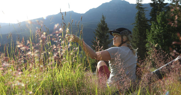 女山地车放松在鲜花草地在日出图片下载