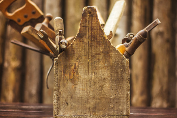 古董工具箱立在红色桌子上，木质背景图片下载