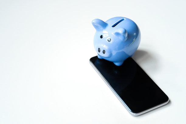 智能手机上的储蓄罐在白色背景的右侧。图片下载