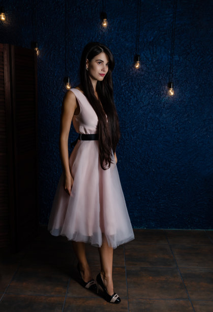 蓝色背景下穿着粉红色裙子的长发女孩图片下载