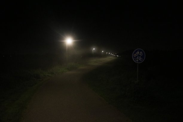 在卡佩尔和纽沃克克和伊塞尔登之间的小自行车道，雾霭中的路灯图片下载