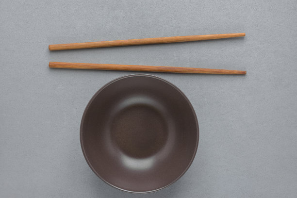 暗空陶瓷碗竹筷子在灰色的石头背景。日本料理中国料理亚洲料理概念。菜单海报模板与复制空间图片下载