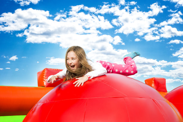 快乐女孩在充气城堡上跳图片下载