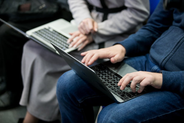 一张笔记本电脑的图片。女孩把它放在腿上。她的手指在键盘上。女人类型。她工作图片下载