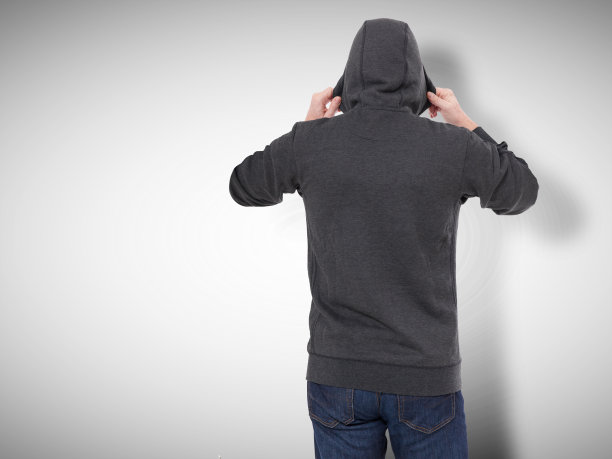 穿黑运动衫的男人，黑帽衫的后视镜。灰色背景图片下载