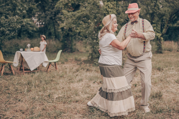 一对快乐的老人在公园里跳舞。祖父看着祖母的眼睛。他们记得年轻的时候。Nastalgiya。祖父母在一起的照片图片下载