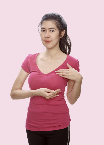 亚洲妇女穿着粉红色的上衣检查她的乳房反对疯牛病或乳房自我检查。乳腺癌检查指南。图片下载