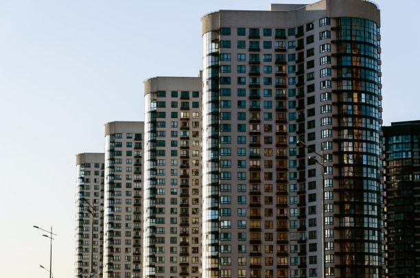 一排现代化的高层建筑映衬着清澈的蓝天。城市背景。城市扩张的概念图片下载