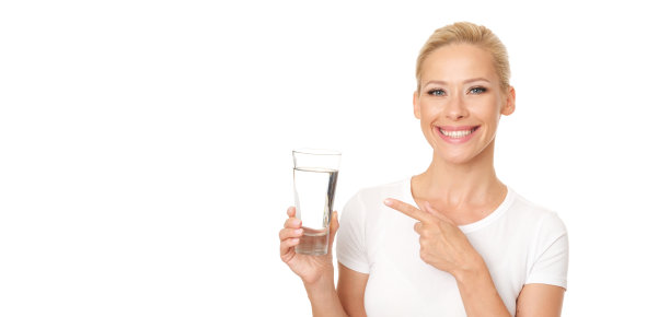 健康的金发女人用手指着一杯水。图片下载