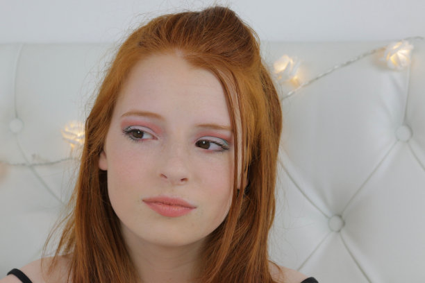 这张照片是一个14 / 15岁的红发少女，皮肤苍白，脸上有雀斑。她坐在卧室里测试眼睑上眼影的颜色，用裸唇画了夸张的眼妆，社交媒体上的化妆视频展示了全脸化妆产品的结果图片下载