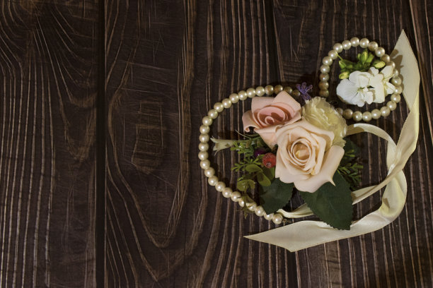木制背景上的珠宝和鲜花，照片图片下载