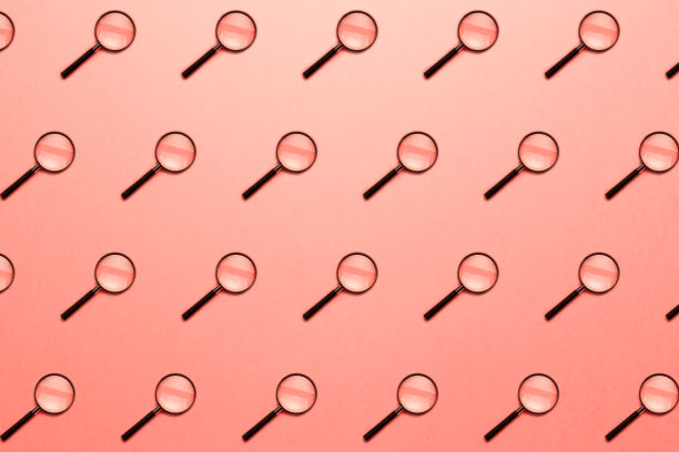 时髦的模式与放大镜在明亮的浅珊瑚背景。信息搜索概念。以彩色纸为背景的简约风格。最小的创意概念。活的珊瑚图片下载