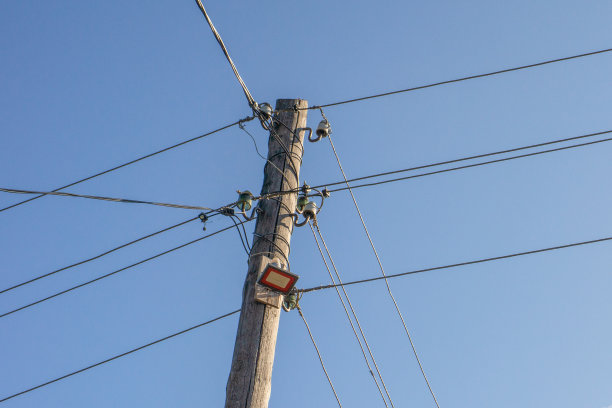模糊的天空背景上的电线杆图片下载