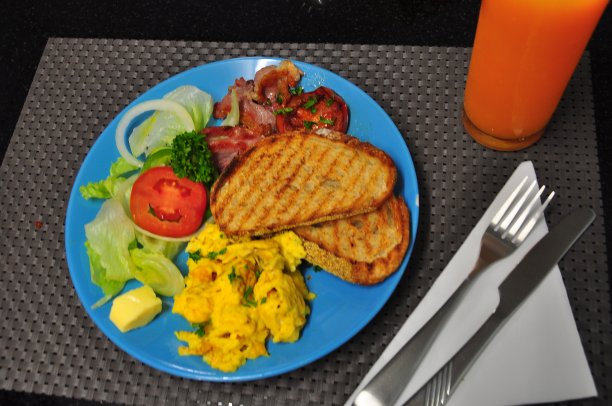 大的健康煎早餐，有鸡蛋、培根、吐司、沙拉、黄油、果汁。图片下载