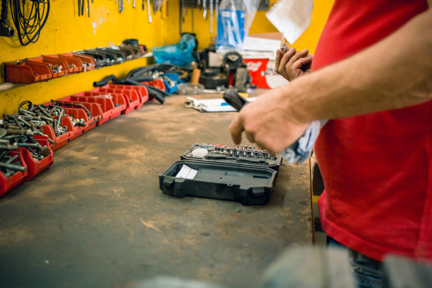 汽车修理工从工具箱中为钻床选择合适的加长件图片下载