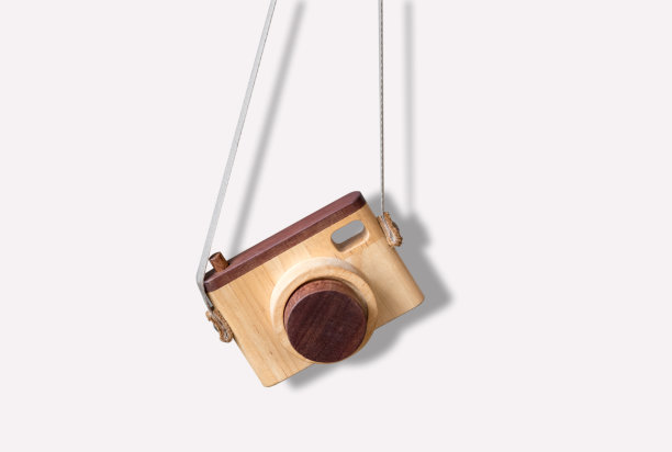 木制玩具作为相机与相机带和下落阴影孤立在白色背景。图片下载
