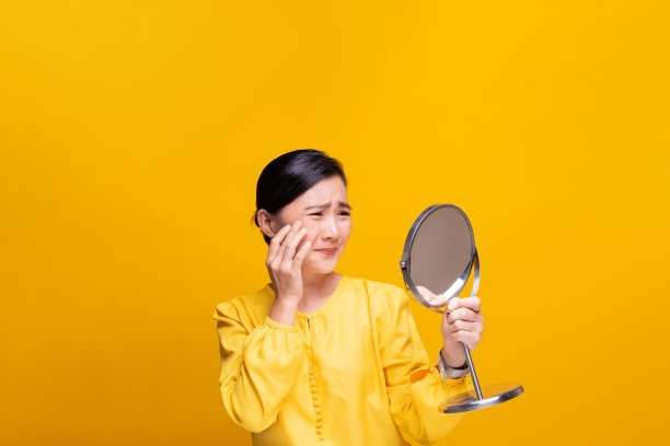 女人看着镜子，担心她脸上的皱纹图片下载