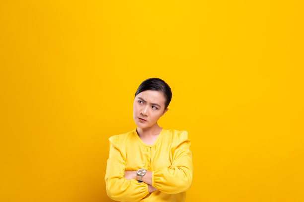 愤怒的女人孤立地站在黄色的背景上图片下载