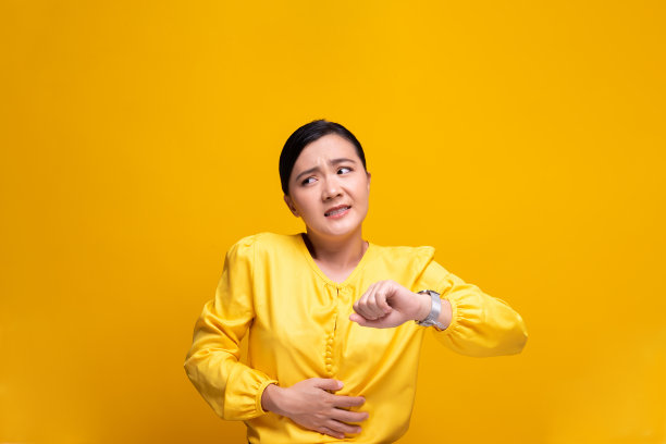 女人有胃痛孤立在黄色背景图片下载