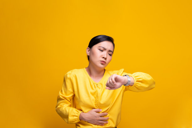 女人有胃痛孤立在黄色背景图片下载