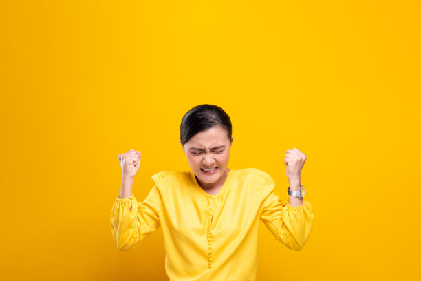 愤怒的女人孤立地站在黄色的背景上图片下载