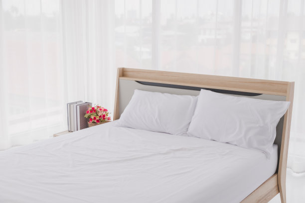 白色的卧室内部有窗户。房间里有干净的白色床和枕头。图片下载
