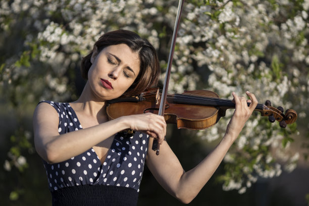 在户外拉小提琴的年轻女子图片下载