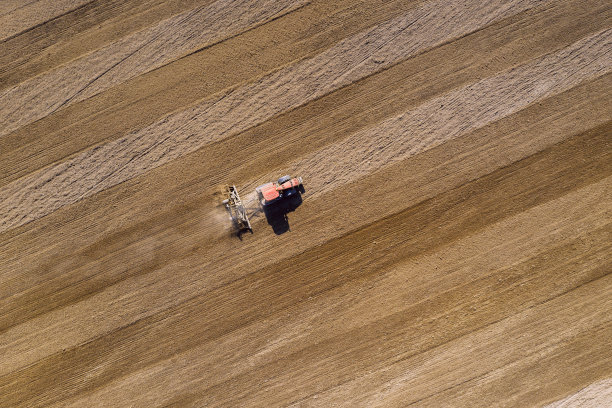 拖拉机耕地。空中无人机拍摄。图片下载