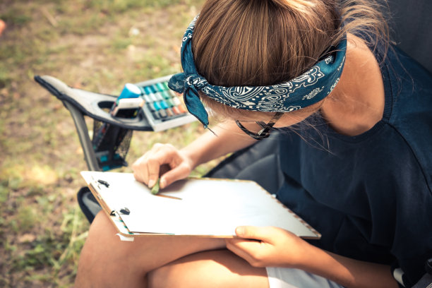 快乐的年轻创意少女素描户外创作过程图片下载