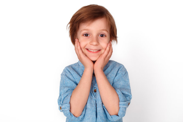 男孩工作室孤立地站在灰色的脸看着相机快乐的特写图片下载