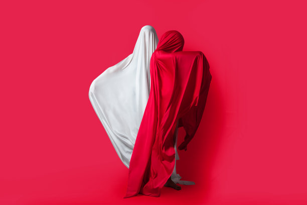 女性形象在风中飘扬。红色和白色的剪影在一个红色的背景在工作室。极简主义。概念图片下载
