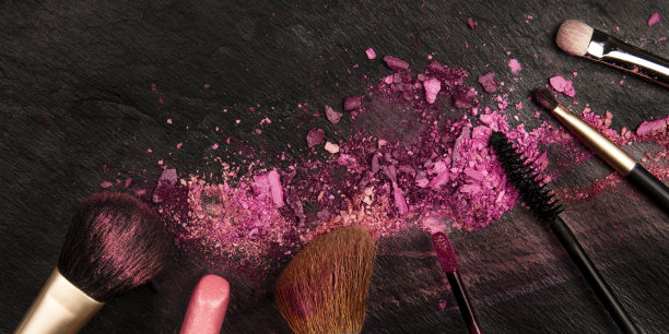 这是一幅化妆刷和唇膏的全景图，上面是深色的背景，上面有一个美丽的设计模板图片下载