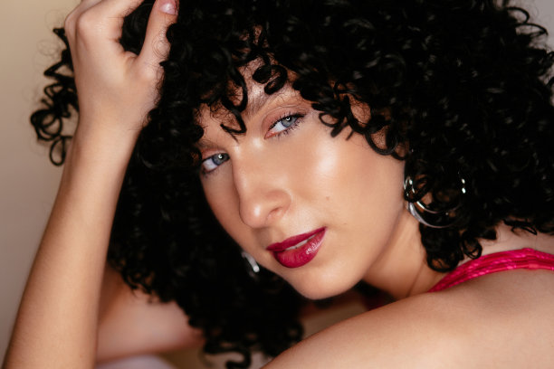 戴着黑色卷曲假发的漂亮年轻女孩图片下载