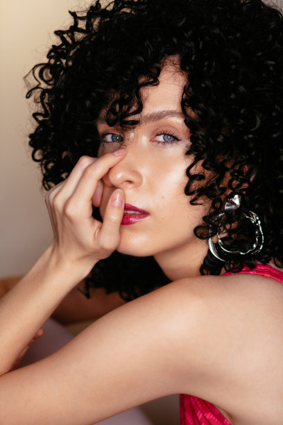 戴着黑色卷曲假发的漂亮年轻女孩图片下载