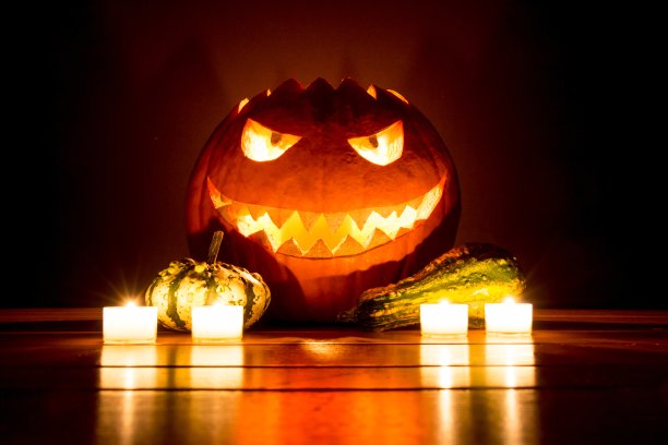 幽灵雕刻的万圣节南瓜与蜡烛和小南瓜图片下载