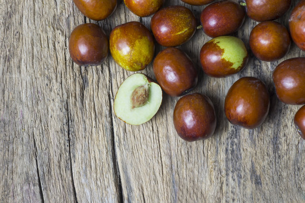 新鲜成熟的红枣水果在木乡村的背景。健康的水果清洁血液，含有维生素c图片下载