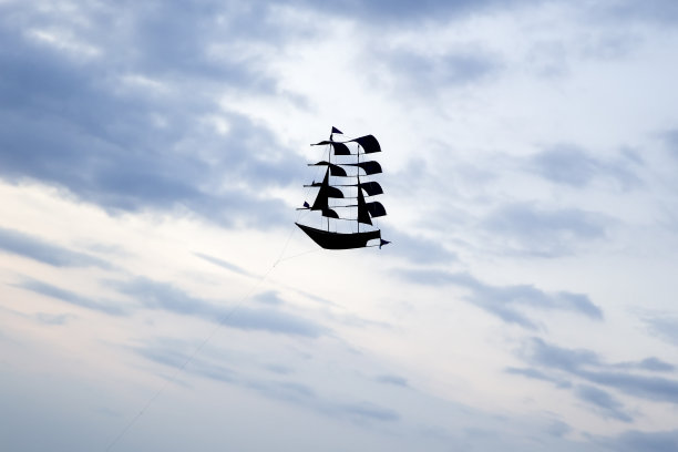 黑色帆船风筝在Puna Tanah Lot寺庙附近的海滩，印度尼西亚巴厘岛图片下载