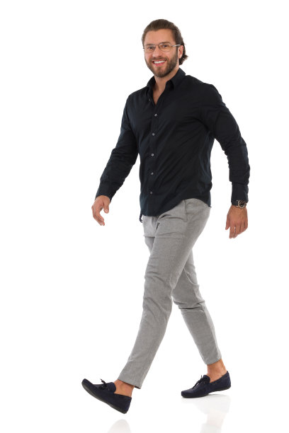 自信优雅的男人正在行走，看着镜头。侧视图。图片下载